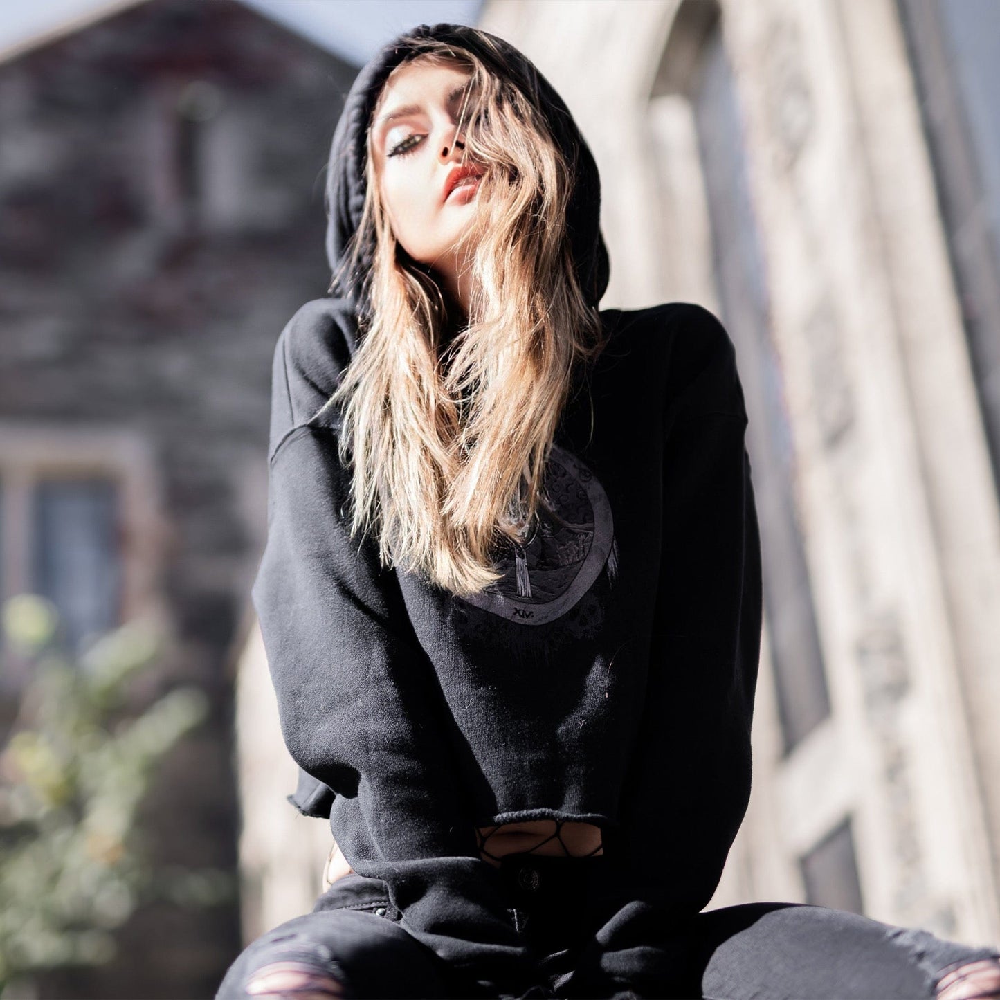 Model wearing Illuminor Crop Hoodie in a gothic setting from Mr. Serial Killer