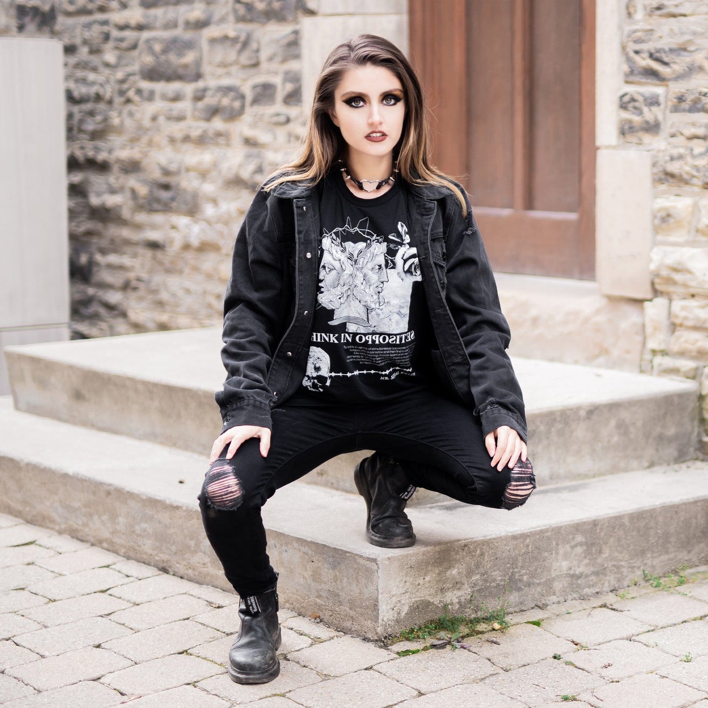 Model wearing Head of Janus Graphic T-Shirt in a gothic setting from Mr. Serial Killer's Shop