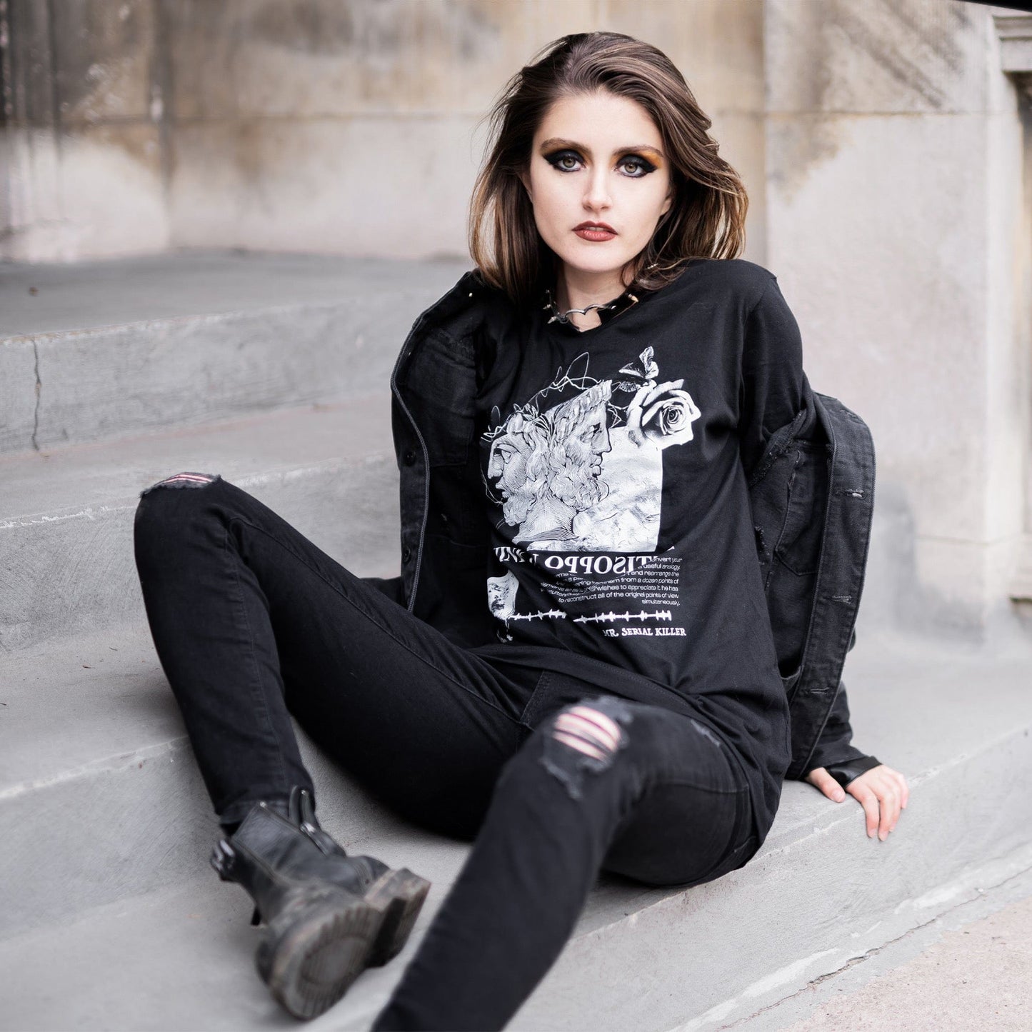 Model wearing Head of Janus Graphic T-Shirt in a gothic setting from Mr. Serial Killer's Shop