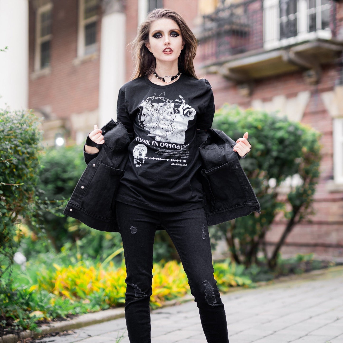 Model wearing Head of Janus Graphic T-Shirt in a gothic setting from Mr. Serial Killer's Shop