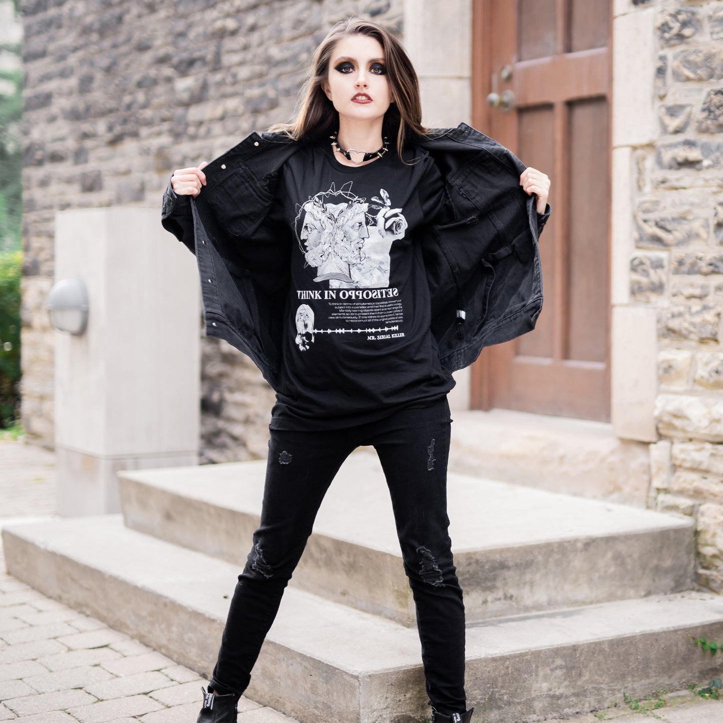 Model wearing Head of Janus Graphic T-Shirt in a gothic setting from Mr. Serial Killer's Shop