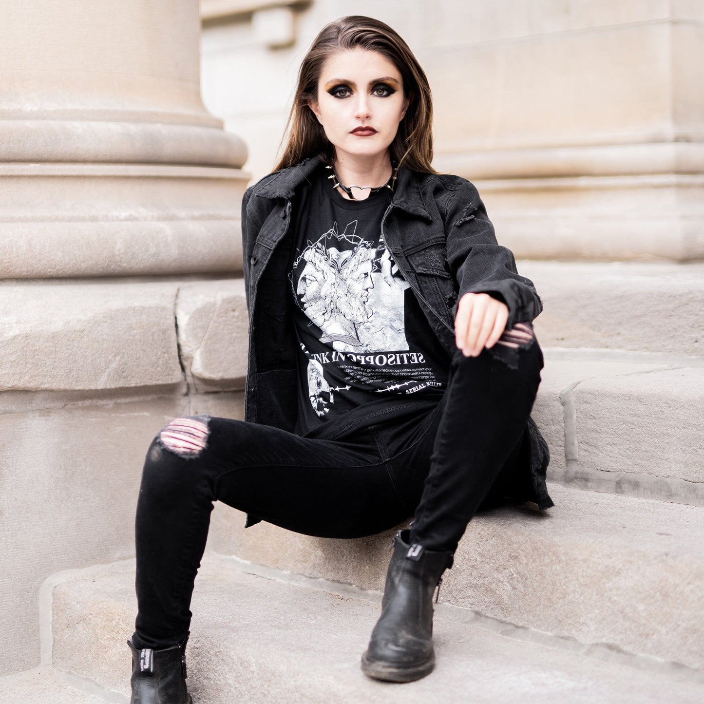 Model wearing Head of Janus Graphic T-Shirt in a gothic setting from Mr. Serial Killer's Shop