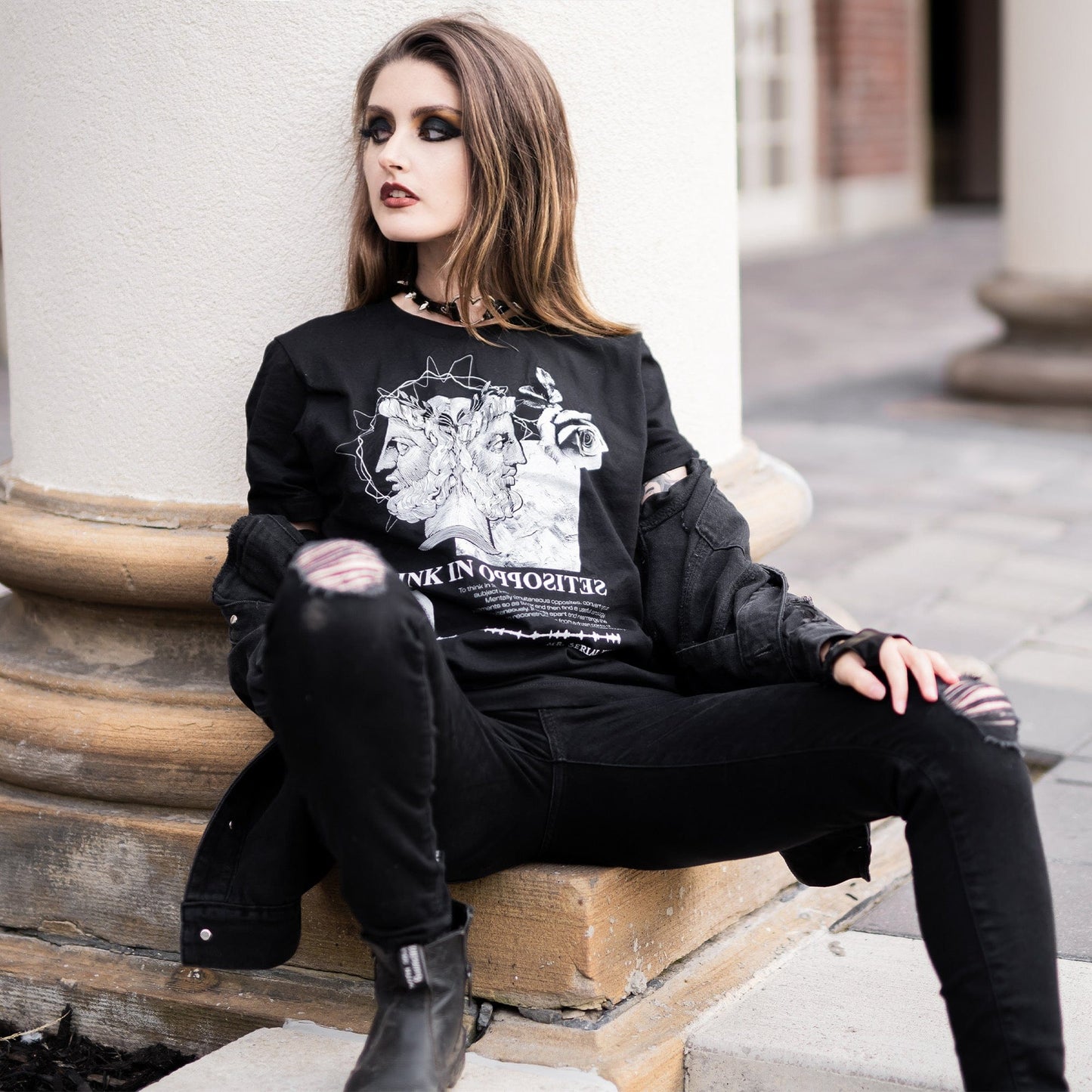 Model wearing Head of Janus Graphic T-Shirt in a gothic setting from Mr. Serial Killer's Shop