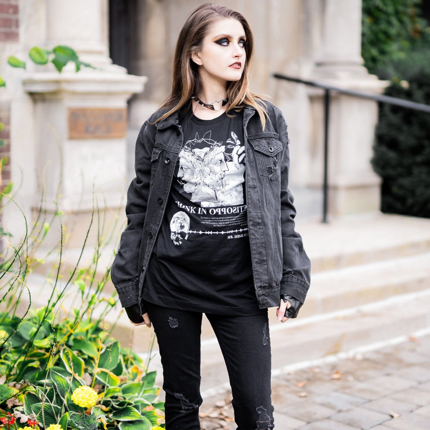 Model wearing Head of Janus Graphic T-Shirt in a gothic setting from Mr. Serial Killer's Shop