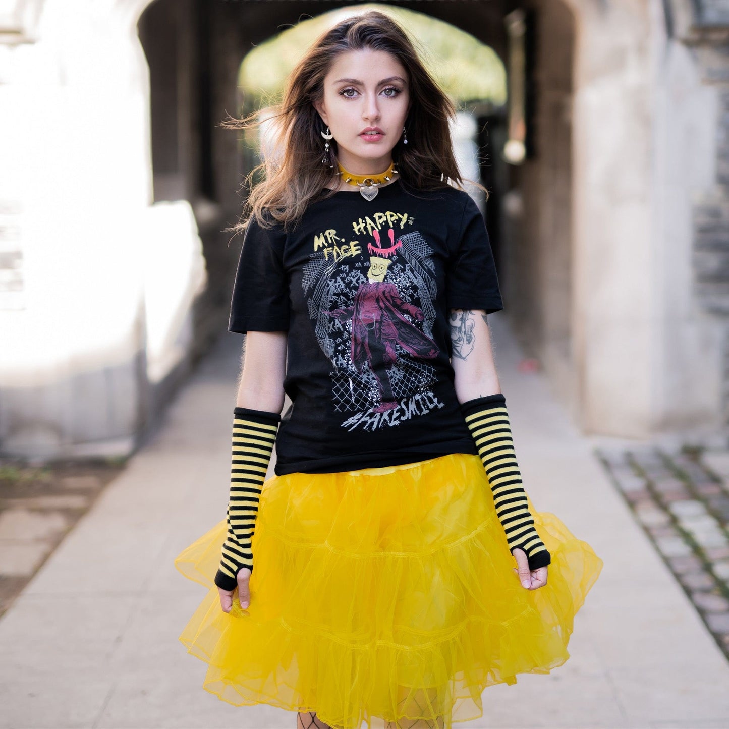 Gothic model wearing Mr. Happy Face Graphic T-Shirt in a Victorian setting