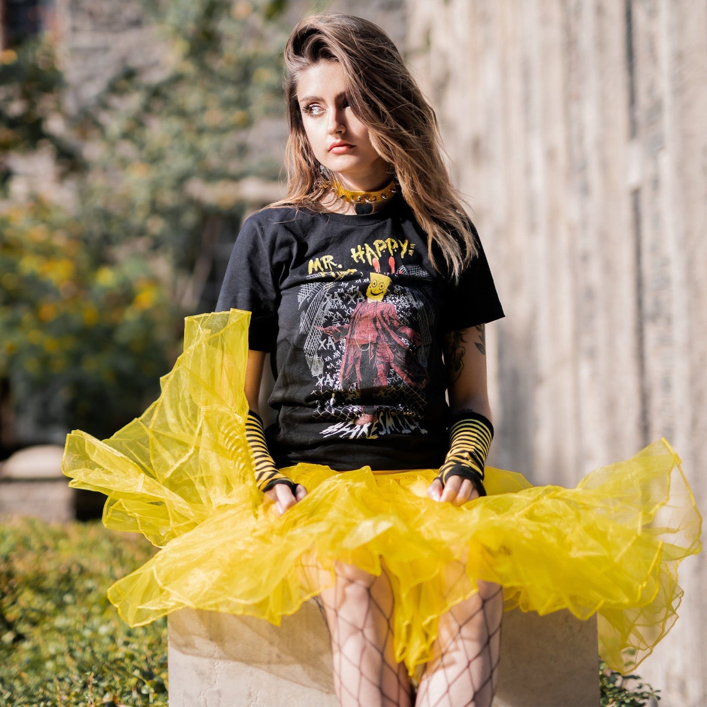 Gothic model wearing Mr. Happy Face Graphic T-Shirt in a Victorian setting
