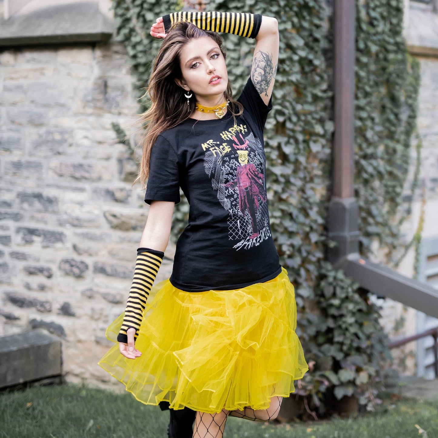 Gothic model wearing Mr. Happy Face Graphic T-Shirt in a Victorian setting