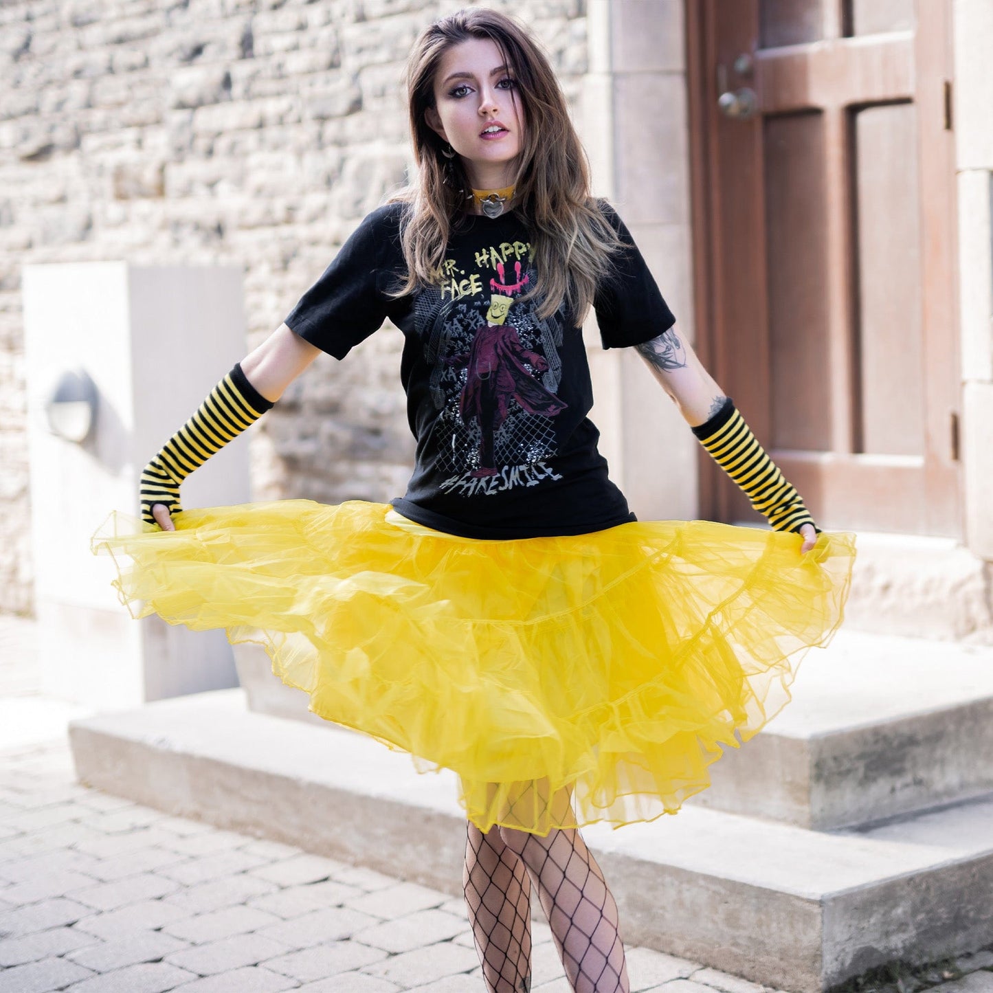 Gothic model wearing Mr. Happy Face Graphic T-Shirt in a Victorian setting
