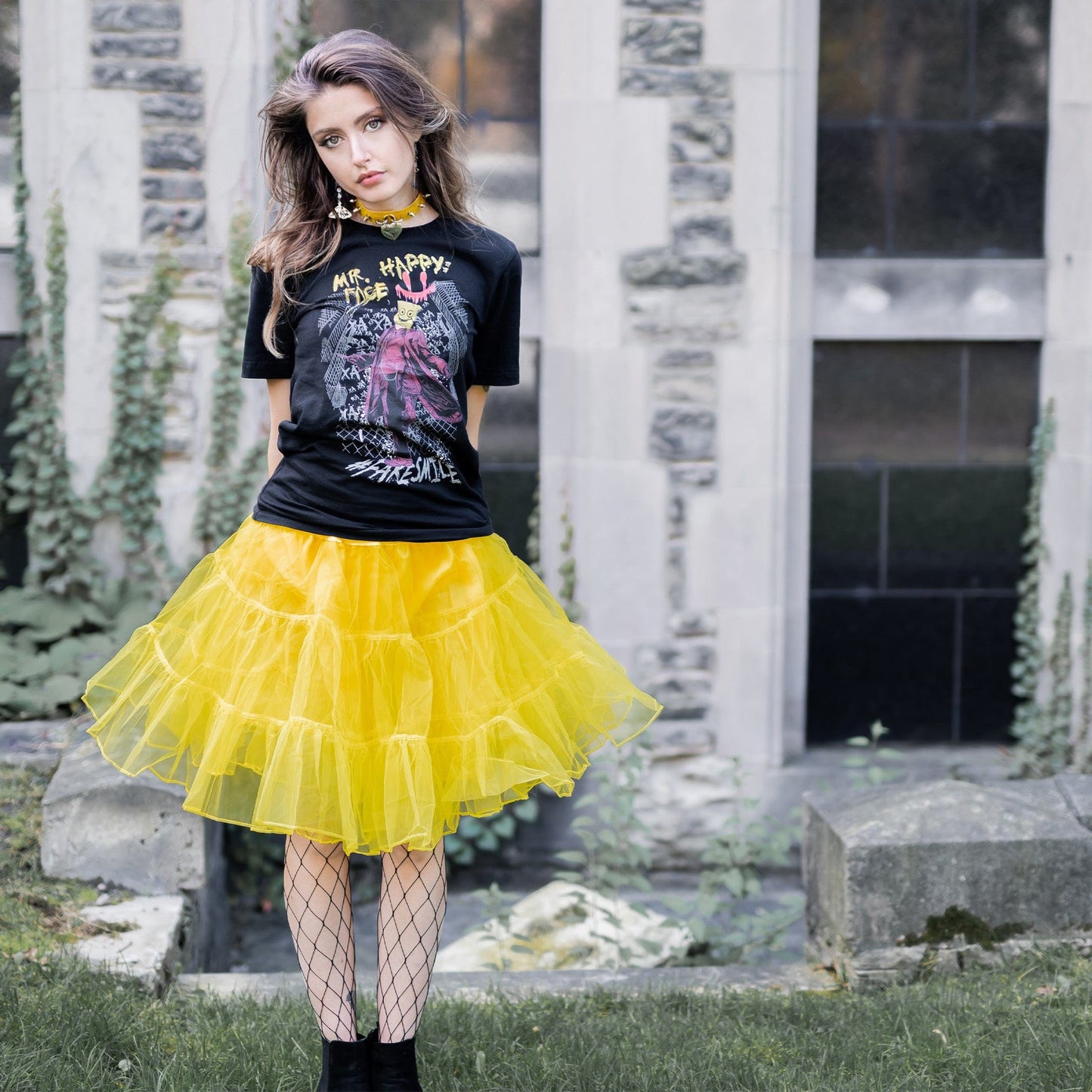 Gothic model wearing Mr. Happy Face Graphic T-Shirt in a Victorian setting