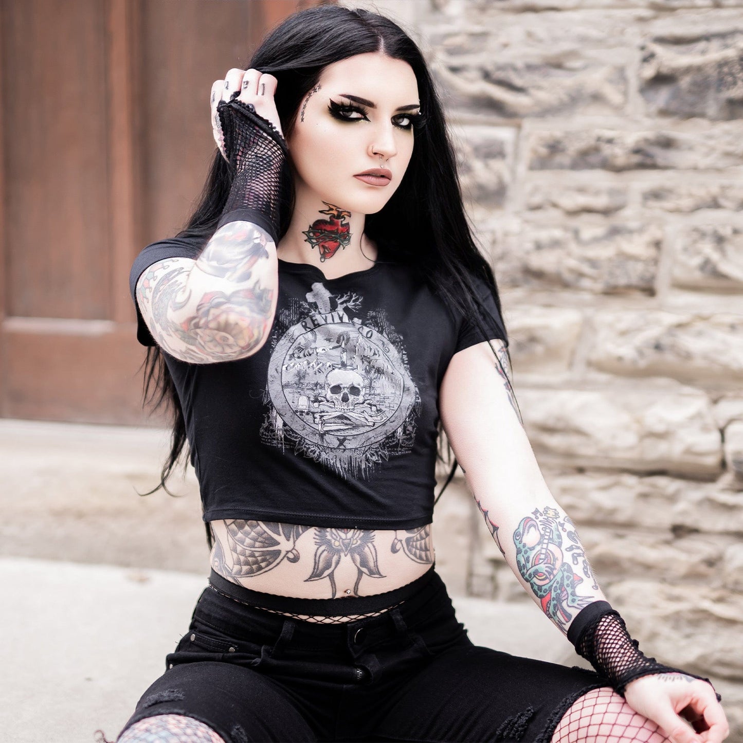 Goth model wearing the Revivisco Graphic Crop Top, showcasing the ancient sigil design and dark aesthetic appeal.