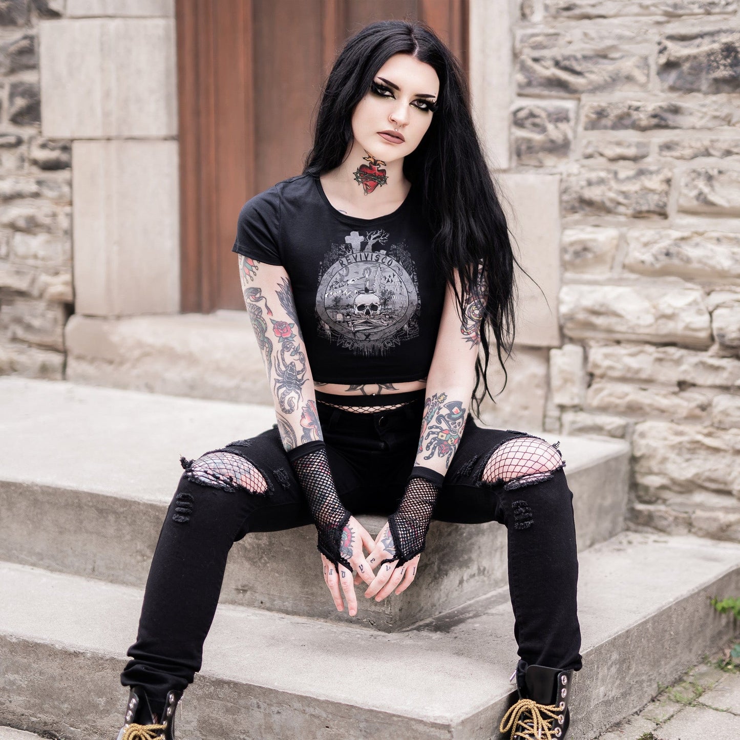 Goth model wearing the Revivisco Graphic Crop Top, showcasing the ancient sigil design and dark aesthetic appeal.