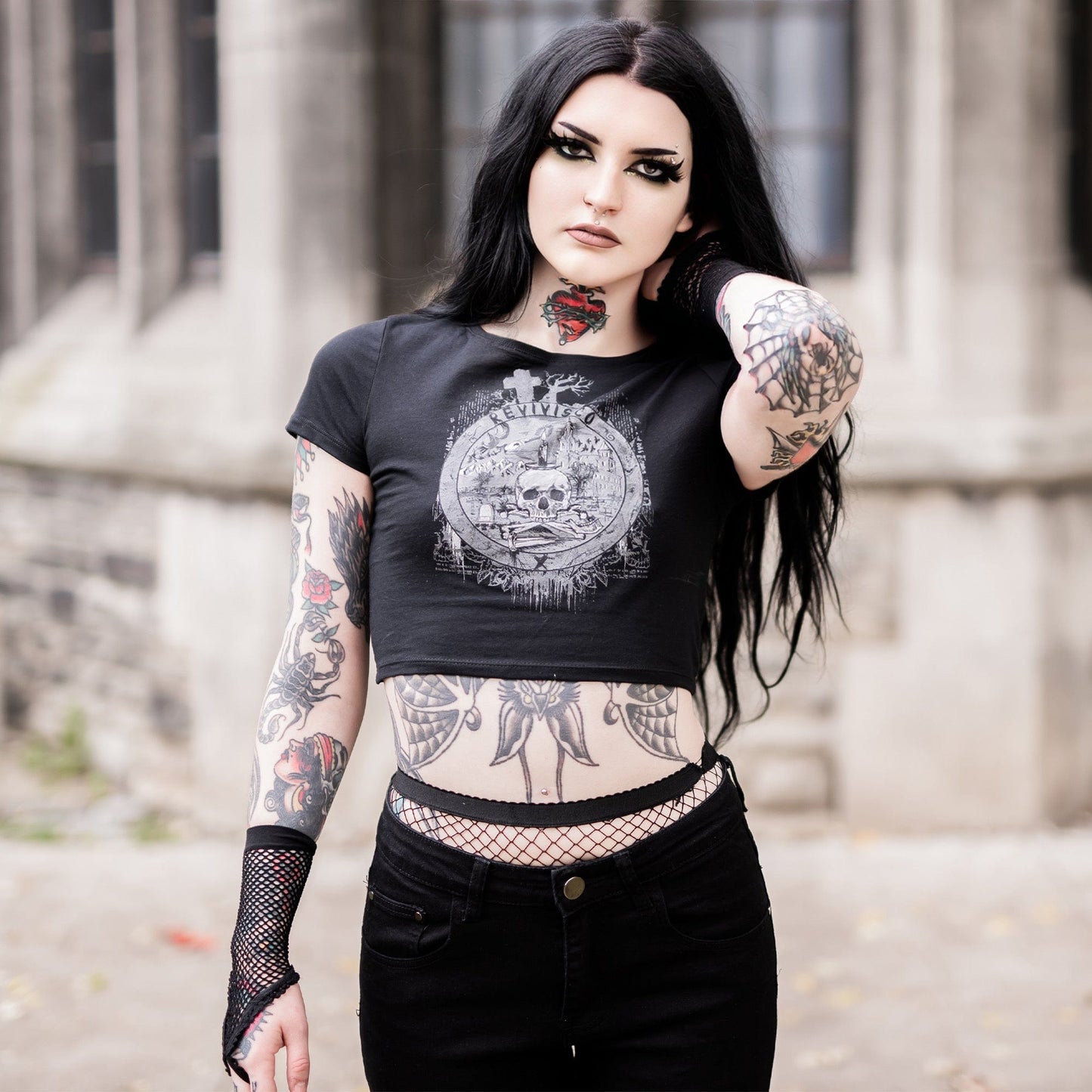 Goth model wearing the Revivisco Graphic Crop Top, showcasing the ancient sigil design and dark aesthetic appeal.