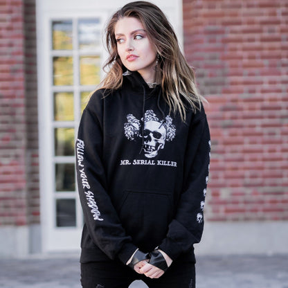 Gothic model wearing the Follow Your Shadow: Mr. Serial Killer Macabre Graphic Black Hoodie in a Victorian setting, embodying dark macabre fashion