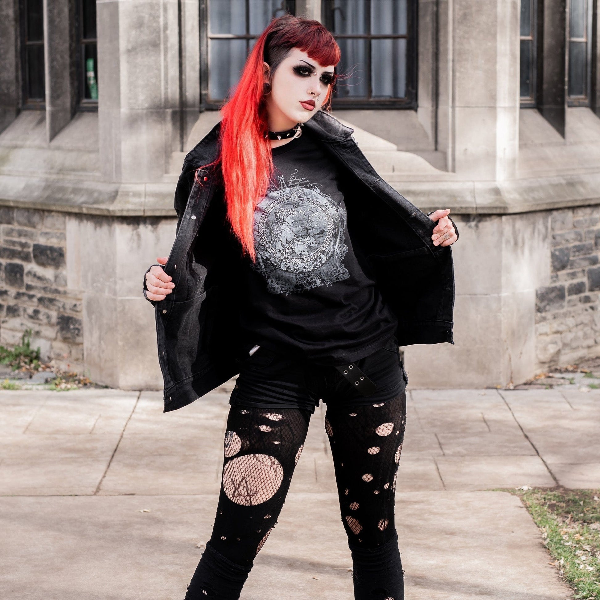 Goth model wearing the Eternal Echoes Graphic T-Shirt with Ouroboros and Divine Child design in a Victorian setting.