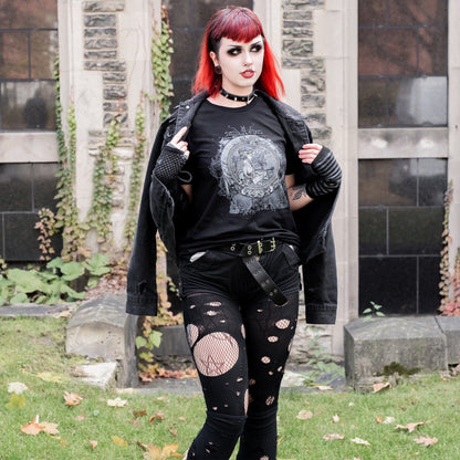 Goth model wearing the Eternal Echoes Graphic T-Shirt with Ouroboros and Divine Child design in a Victorian setting.