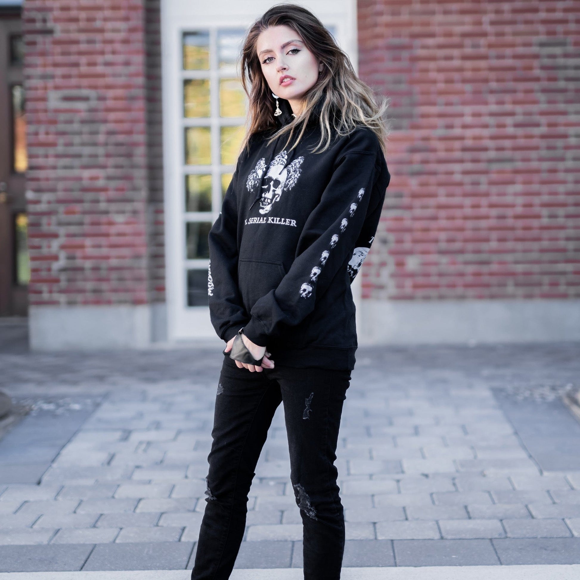 Gothic model wearing the Follow Your Shadow: Mr. Serial Killer Macabre Graphic Black Hoodie in a Victorian setting, embodying dark macabre fashion