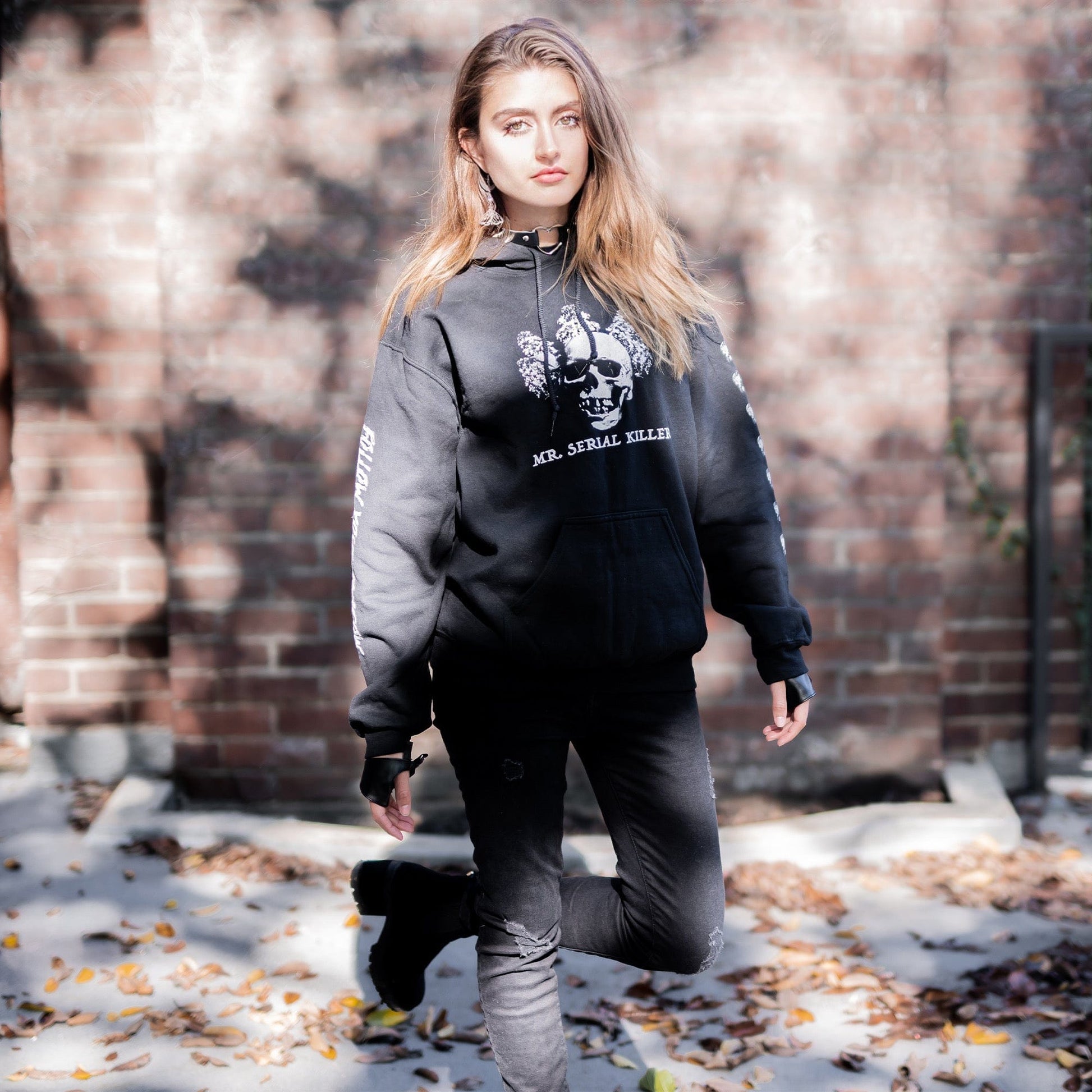 Gothic model wearing the Follow Your Shadow: Mr. Serial Killer Macabre Graphic Black Hoodie in a Victorian setting, embodying dark macabre fashion