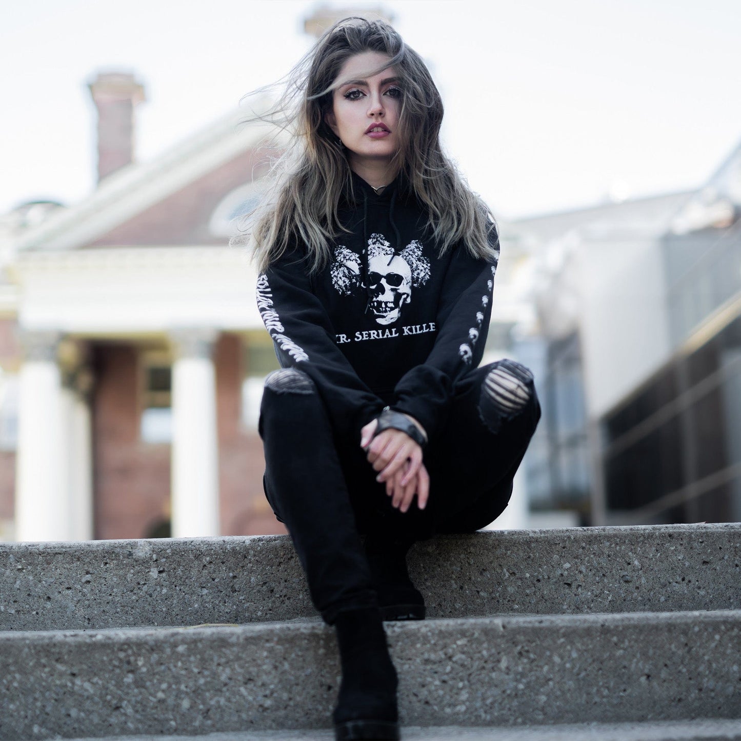 Gothic model wearing the Follow Your Shadow: Mr. Serial Killer Macabre Graphic Black Hoodie in a Victorian setting, embodying dark macabre fashion