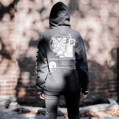 Gothic model wearing the Follow Your Shadow: Mr. Serial Killer Macabre Graphic Black Hoodie in a Victorian setting, embodying dark macabre fashion