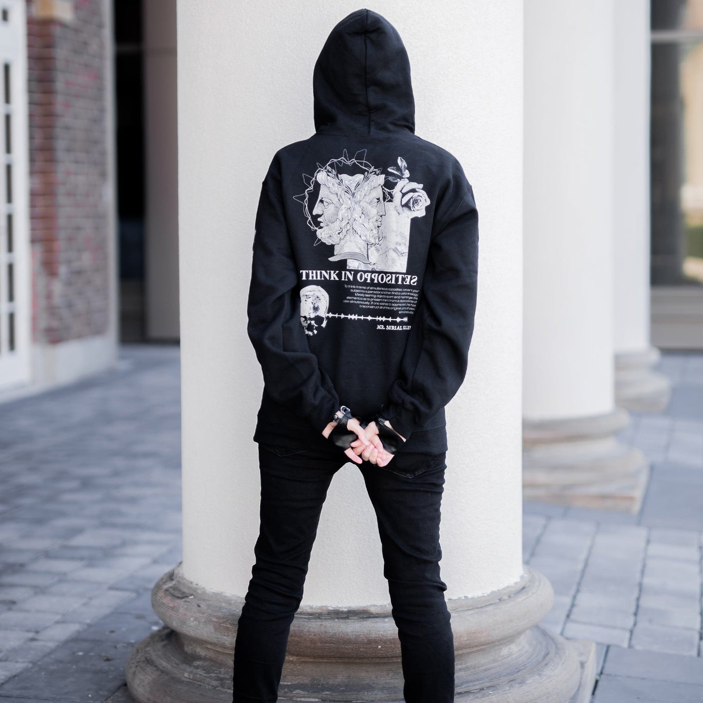 Gothic model wearing the Follow Your Shadow: Mr. Serial Killer Macabre Graphic Black Hoodie in a Victorian setting, embodying dark macabre fashion